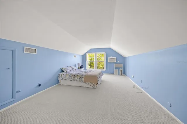 a spacious bedroom with a bed and window