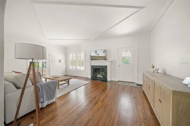 a view of a livingroom with furniture a fireplace and wooden floor