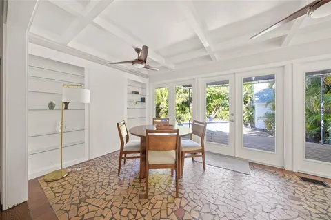 a dining room with furniture a rug and a floor to ceiling window