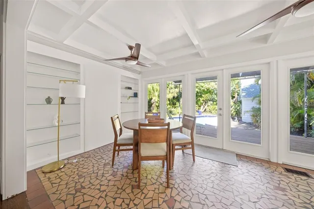 a dining room with furniture a rug and a floor to ceiling window