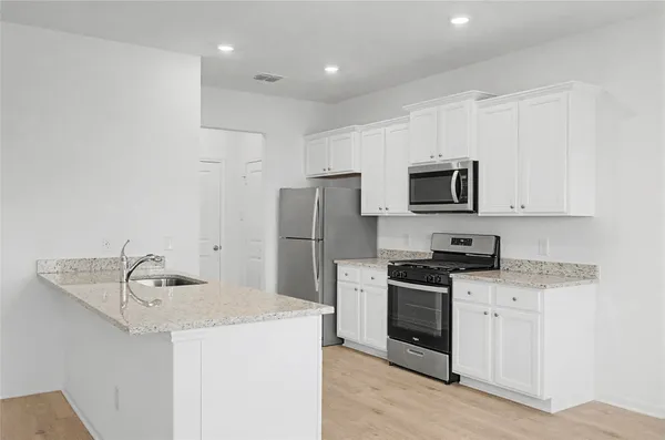 a kitchen that has a sink and a stove top oven