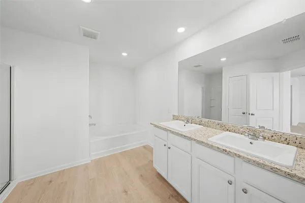a bathroom with a granite countertop sink and a bathtub