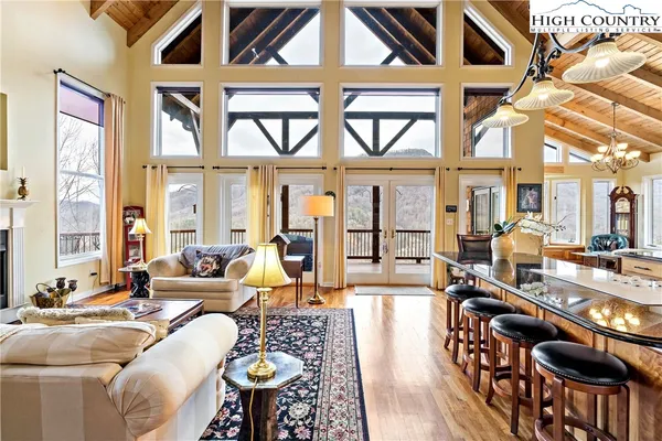 a living room with furniture a fireplace and large windows