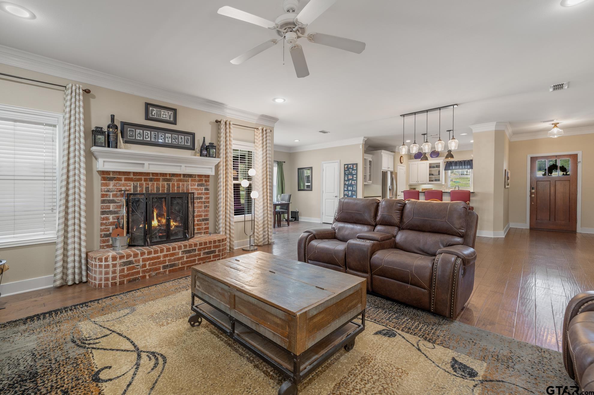9453 Cherokee Trail Tyler, TX 75703 - Photo 6 of 40 a living room with furniture a flat screen tv and a fireplace