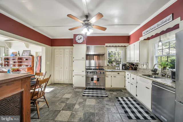 a kitchen with a sink a counter top space appliances and cabinets