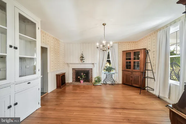 a view of empty room with wooden floor and fireplace