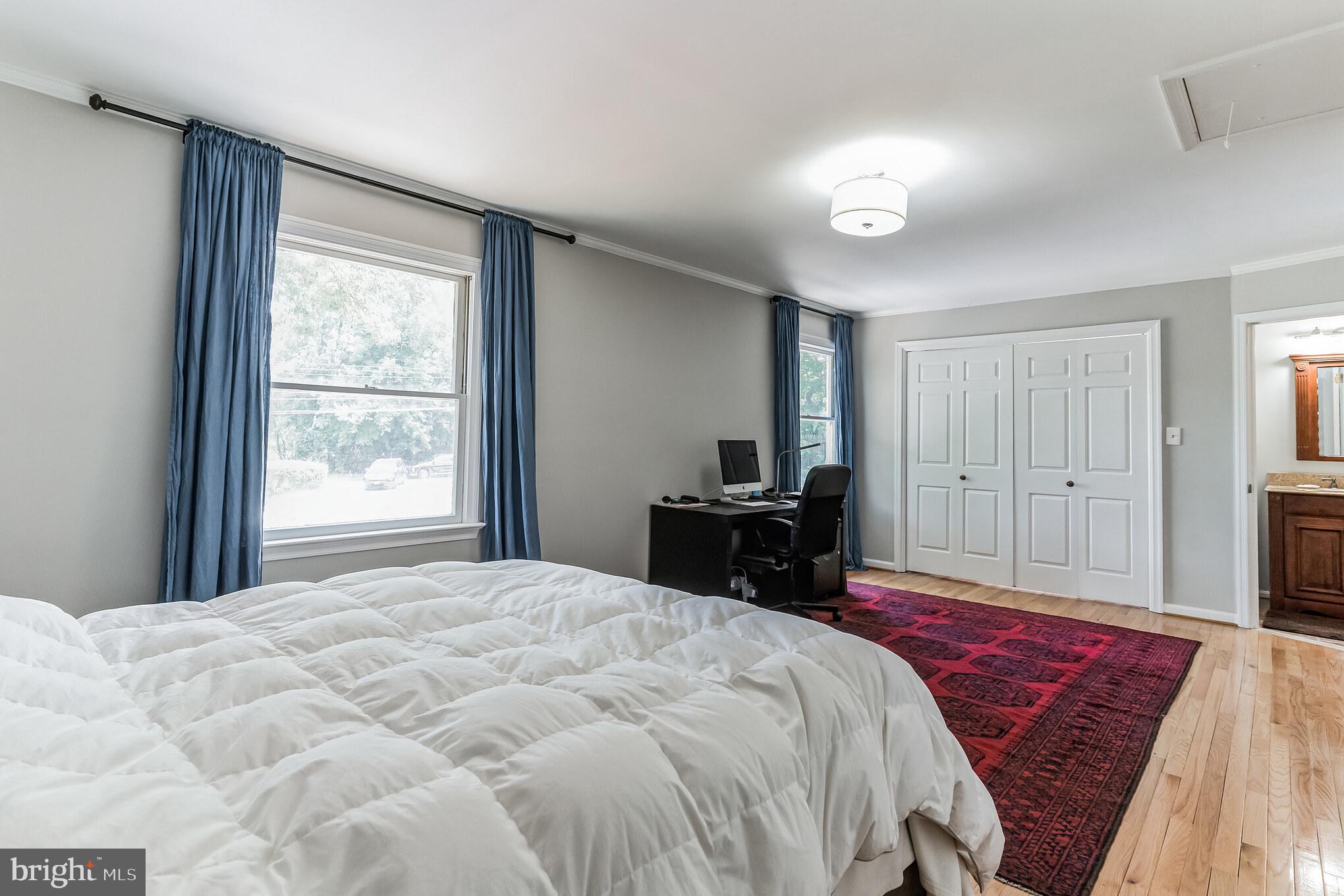 9329 Harvey Road Silver Spring, MD 20910 - Photo 18 of 40 a spacious bedroom with a bed and a chandelier