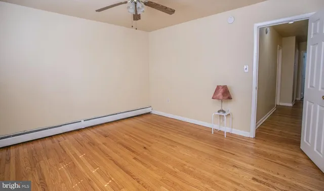 a view of empty room with wooden floor