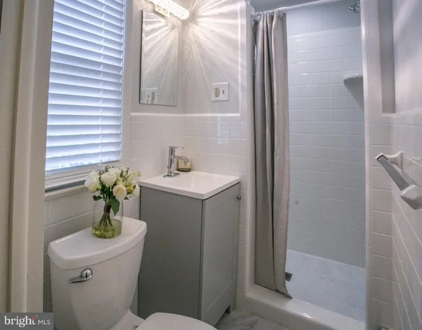 a view of an empty room with wooden floor and closet