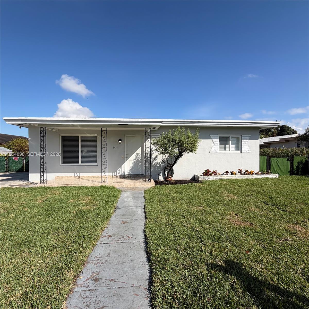 9435-9437 Southwest 39th Street Miami, FL 33165 - Photo 2 of 70 a front view of a house with a yard and garage