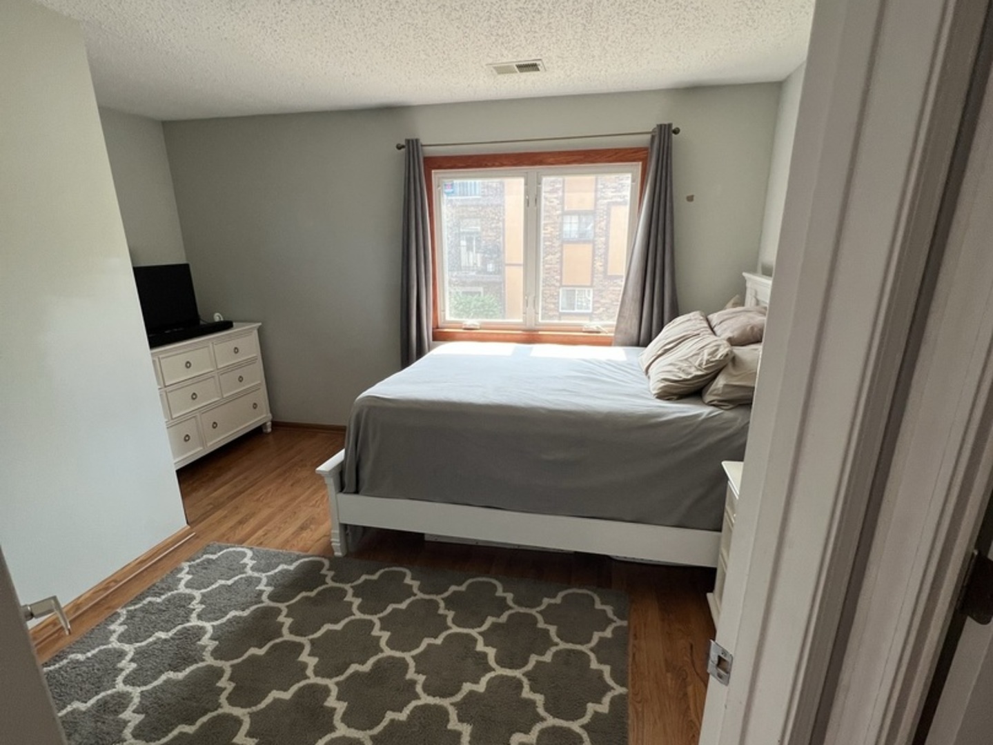1230 Chalet Road, Unit 204 Naperville, IL 60563 - Photo 12 of 17 a bedroom with a bed and wooden floor