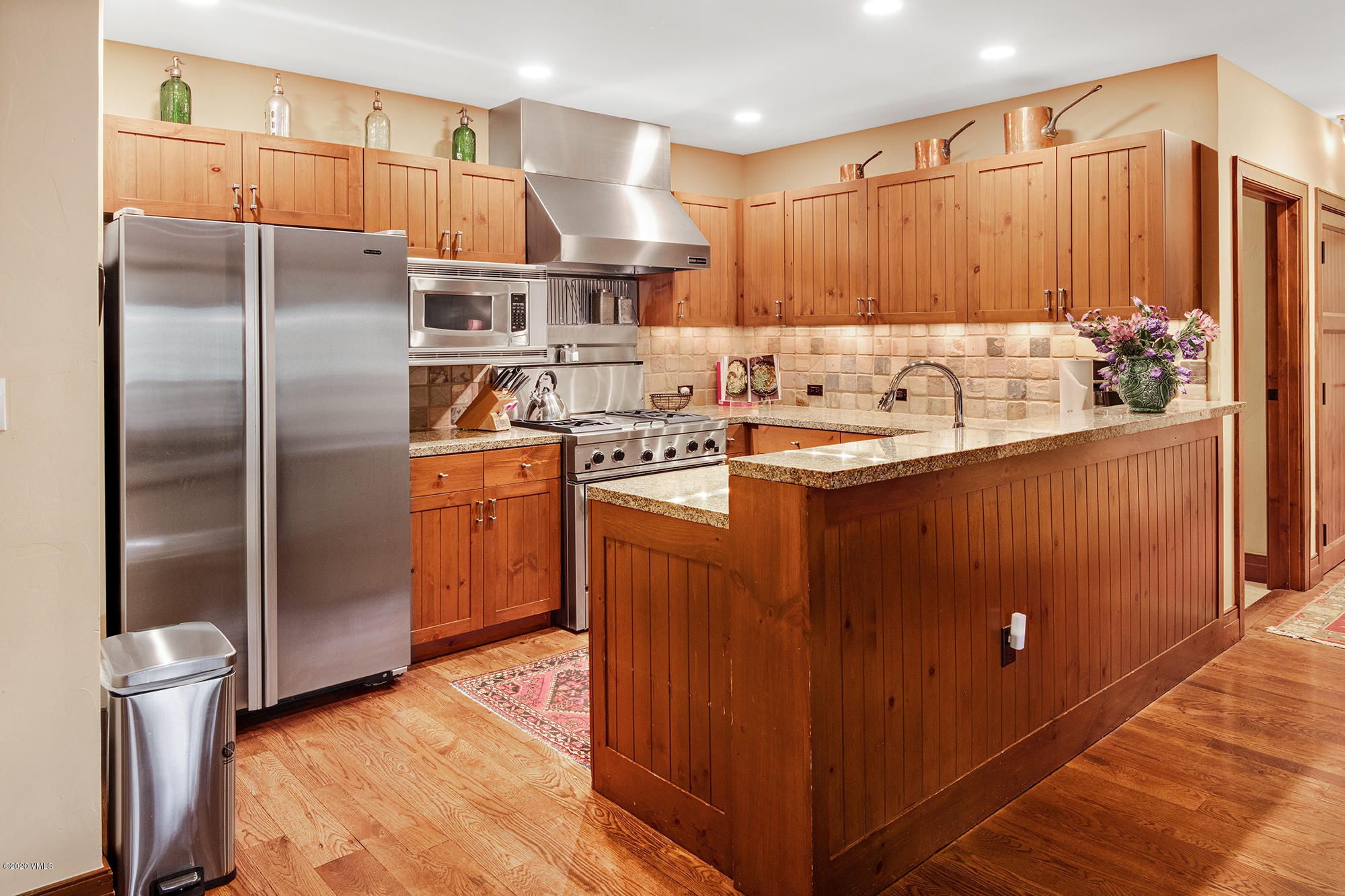 180 Daybreak Ridge Road, Unit 409 Avon, CO 81620 - Photo 14 of 47 a kitchen with stainless steel appliances granite countertop a refrigerator a sink and wooden cabinets
