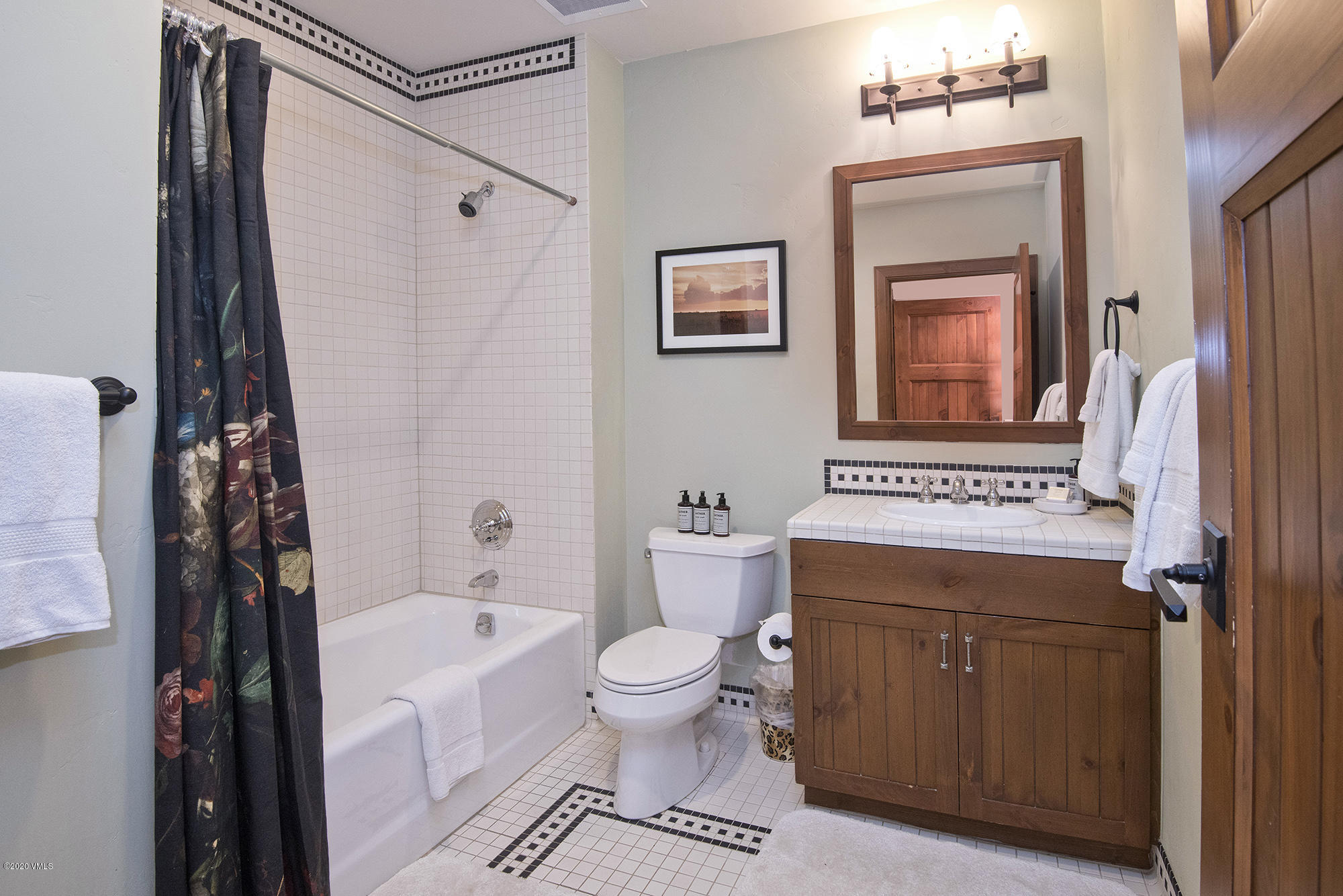 180 Daybreak Ridge Road, Unit 409 Avon, CO 81620 - Photo 23 of 47 a bathroom with a granite countertop sink a mirror a toilet and a bathtub