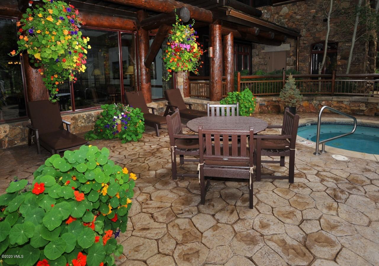 180 Daybreak Ridge Road, Unit 409 Avon, CO 81620 - Photo 6 of 47 a view of a chairs and table in a backyard