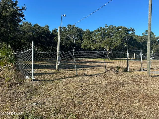 a view of outdoor space with wooden fence and trees