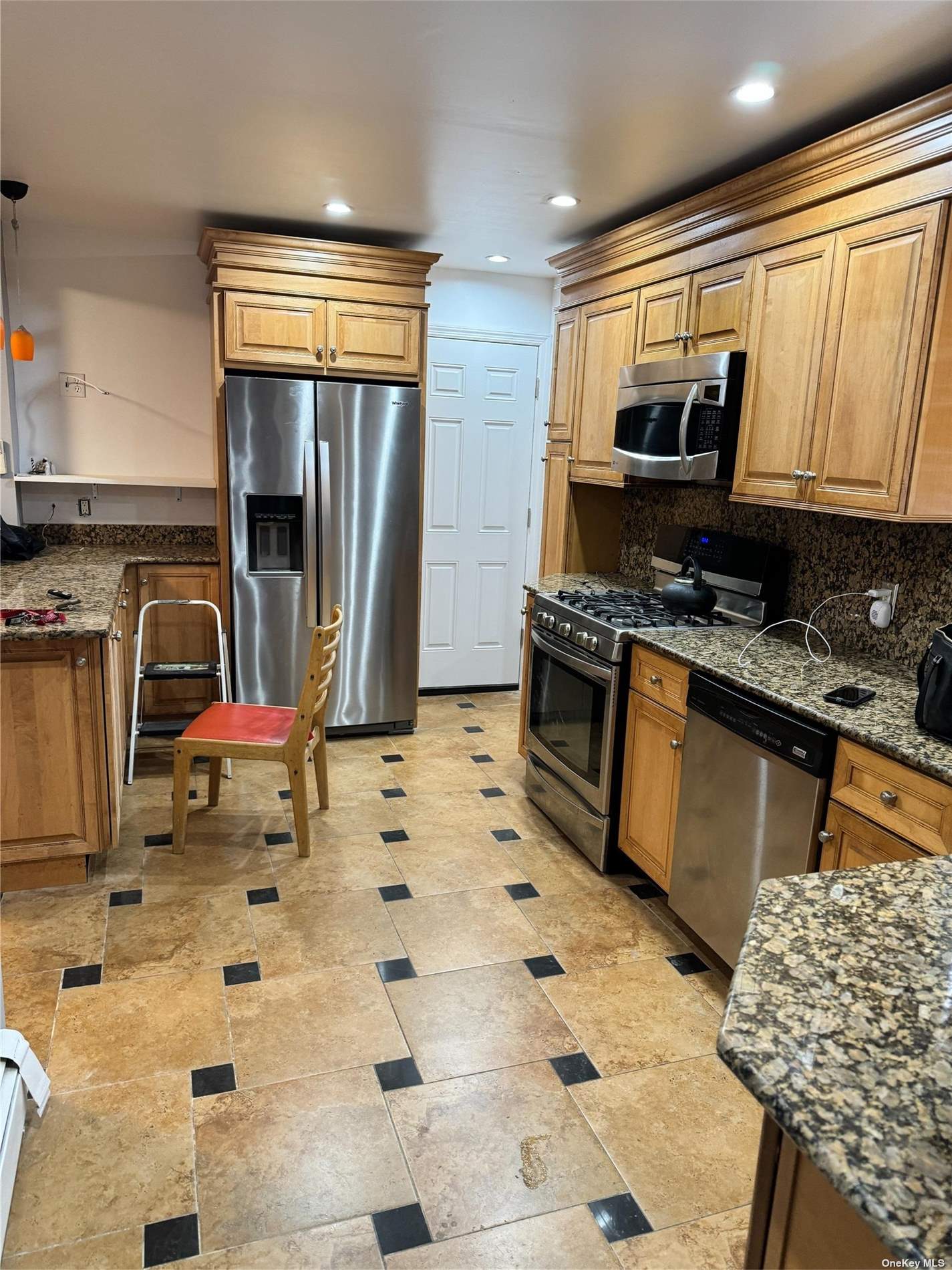 a kitchen with stainless steel appliances a sink stove refrigerator and cabinets