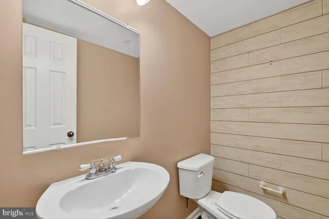 a bathroom with a sink a toilet and mirror