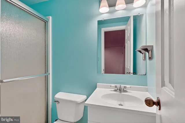 a bathroom with a sink toilet and mirror