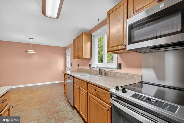a kitchen with stainless steel appliances a sink stove and cabinets