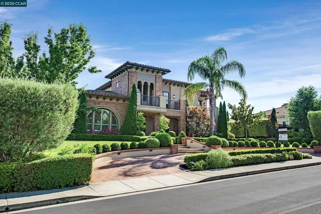 a front view of a house with a yard and potted plants