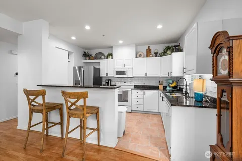 a kitchen with stainless steel appliances kitchen island granite countertop a sink and cabinets