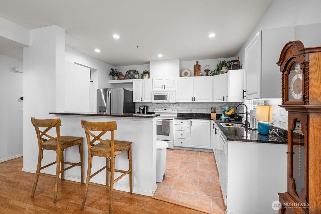 23228 59th Court South Kent, WA 98032 - Photo 8 of 31 a kitchen with stainless steel appliances kitchen island granite countertop a sink and cabinets