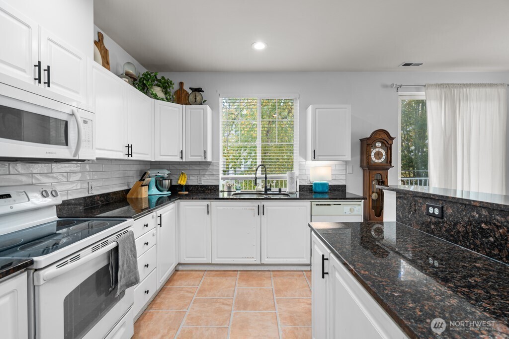 23228 59th Court South Kent, WA 98032 - Photo 10 of 31 a kitchen with granite countertop a sink stainless steel appliances and cabinets
