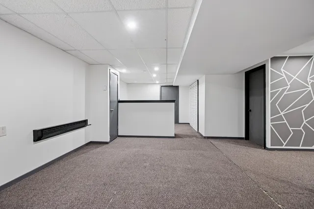 a view of an empty room with furniture and a window