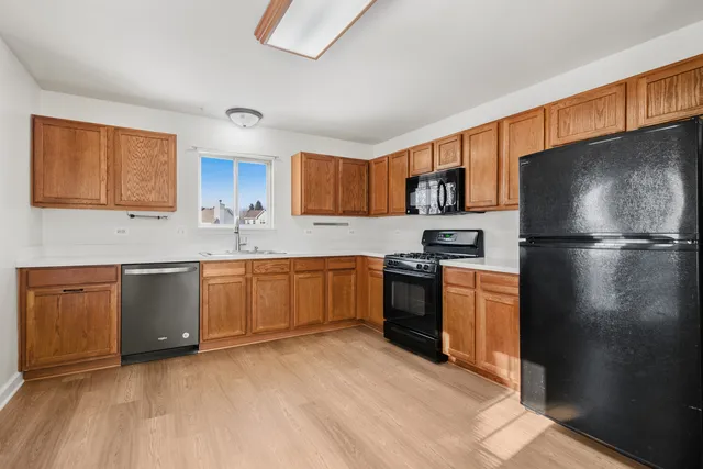 a kitchen with granite countertop a refrigerator stove top oven a sink and dishwasher