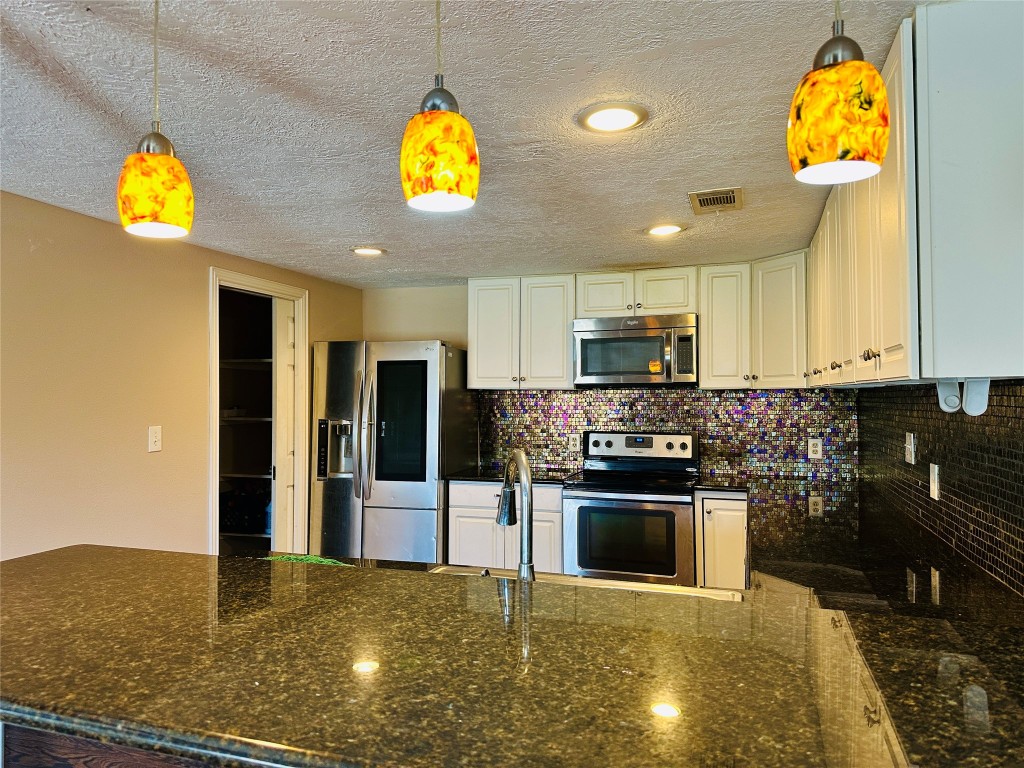 25417 Highway 6 Hempstead, TX 77445 - Photo 18 of 48 a kitchen with stainless steel appliances granite countertop a stove cabinets and microwave