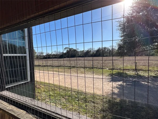 a view of a utility room with fridge and wooden cabinets