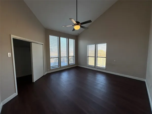 an empty room with wooden floor and windows