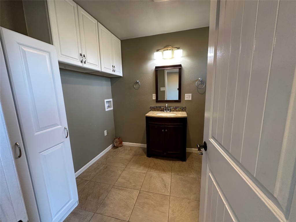 25417 Highway 6 Hempstead, TX 77445 - Photo 39 of 48 a view of a utility room with fridge and wooden cabinets