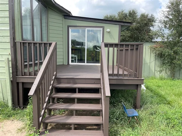 a view of an empty room with wooden floor fireplace and a window
