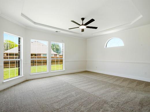 5034 West Fall Drive Midlothian, TX 76065 - Photo 21 of 40 Spacious room featuring a tray ceiling with a ceiling fan, three large windows, an arched window, and plush carpet flooring
