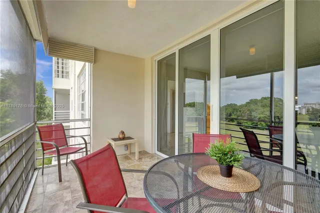 a living room with furniture potted plant floor to ceiling windows and a livingroom