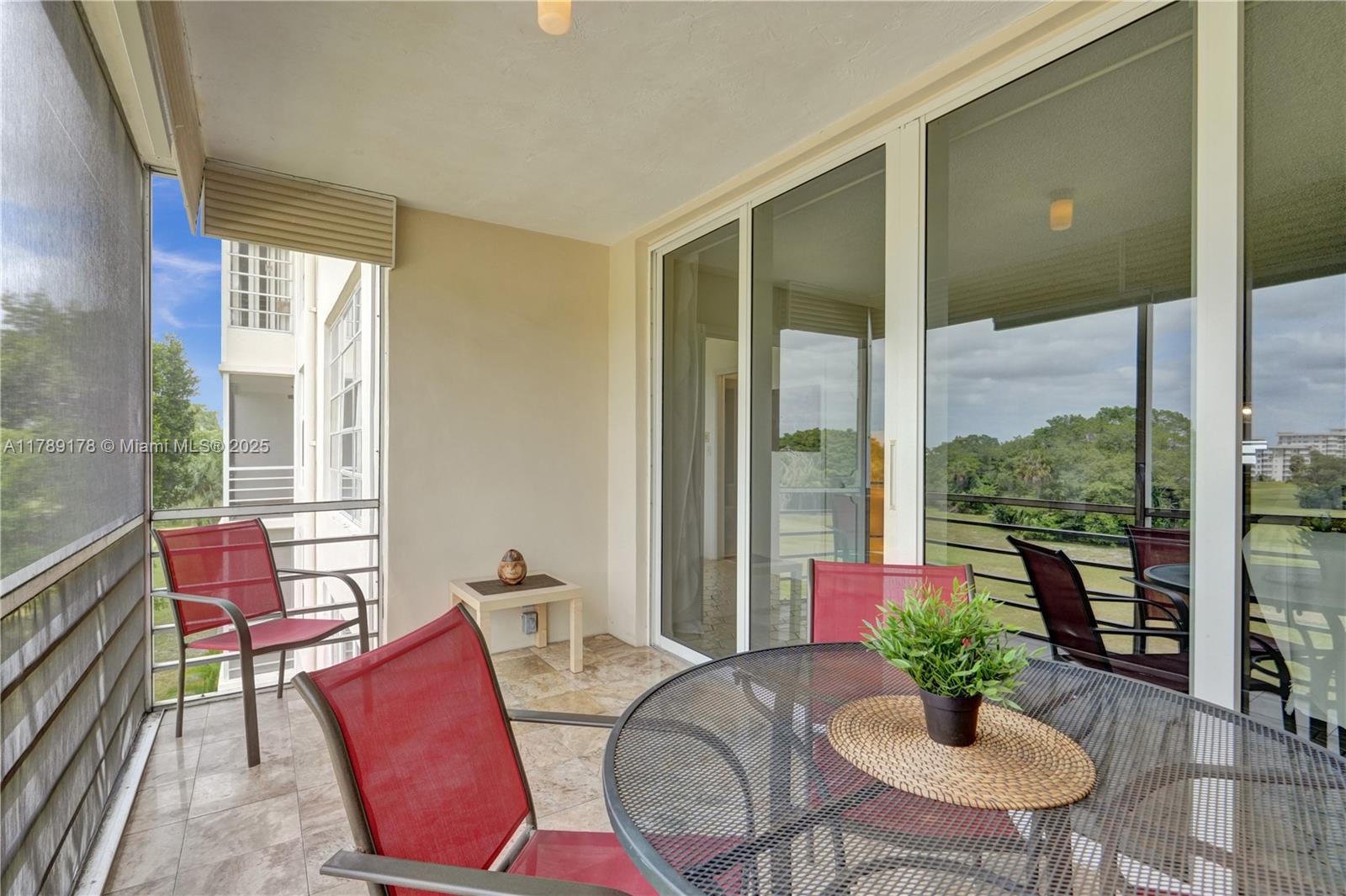 2671 South Course Drive, Unit 409 Pompano Beach, FL 33069 - Photo 13 of 45 a living room with furniture potted plant floor to ceiling windows and a livingroom