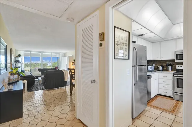 a kitchen with stainless steel appliances kitchen island granite countertop a refrigerator and a sink