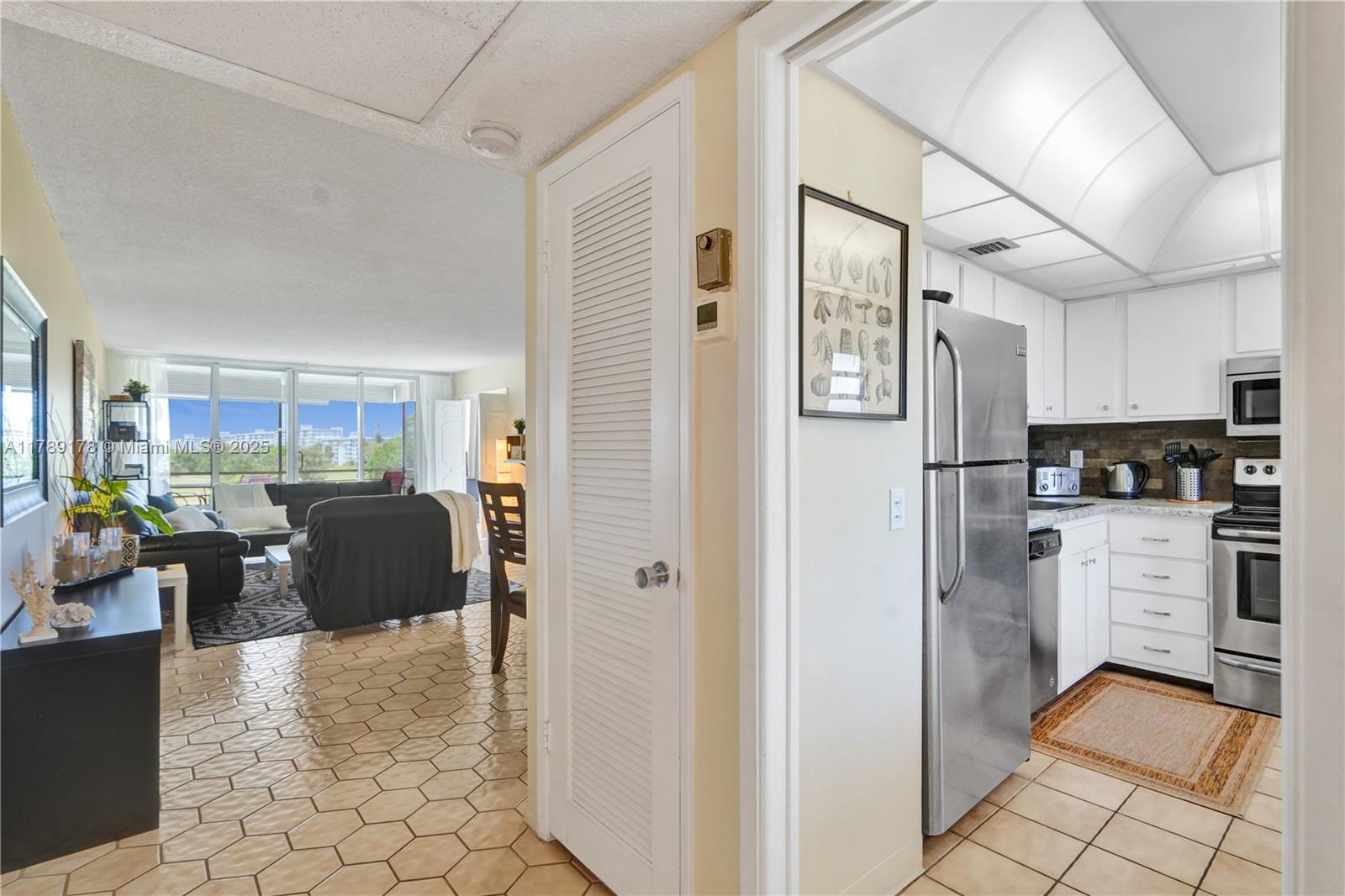 2671 South Course Drive, Unit 409 Pompano Beach, FL 33069 - Photo 20 of 45 a kitchen with stainless steel appliances kitchen island granite countertop a refrigerator and a sink