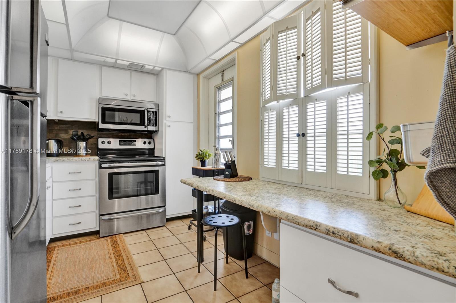 2671 South Course Drive, Unit 409 Pompano Beach, FL 33069 - Photo 21 of 45 a kitchen with stainless steel appliances granite countertop a stove a sink and a microwave
