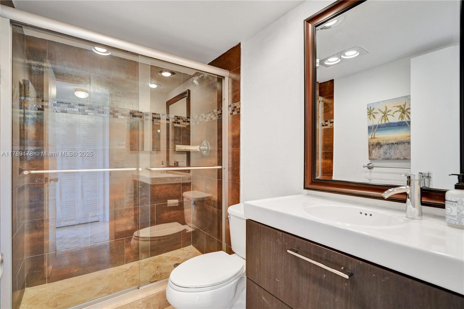 2671 South Course Drive, Unit 409 Pompano Beach, FL 33069 - Photo 25 of 45 a bathroom with a sink a toilet a mirror and shower