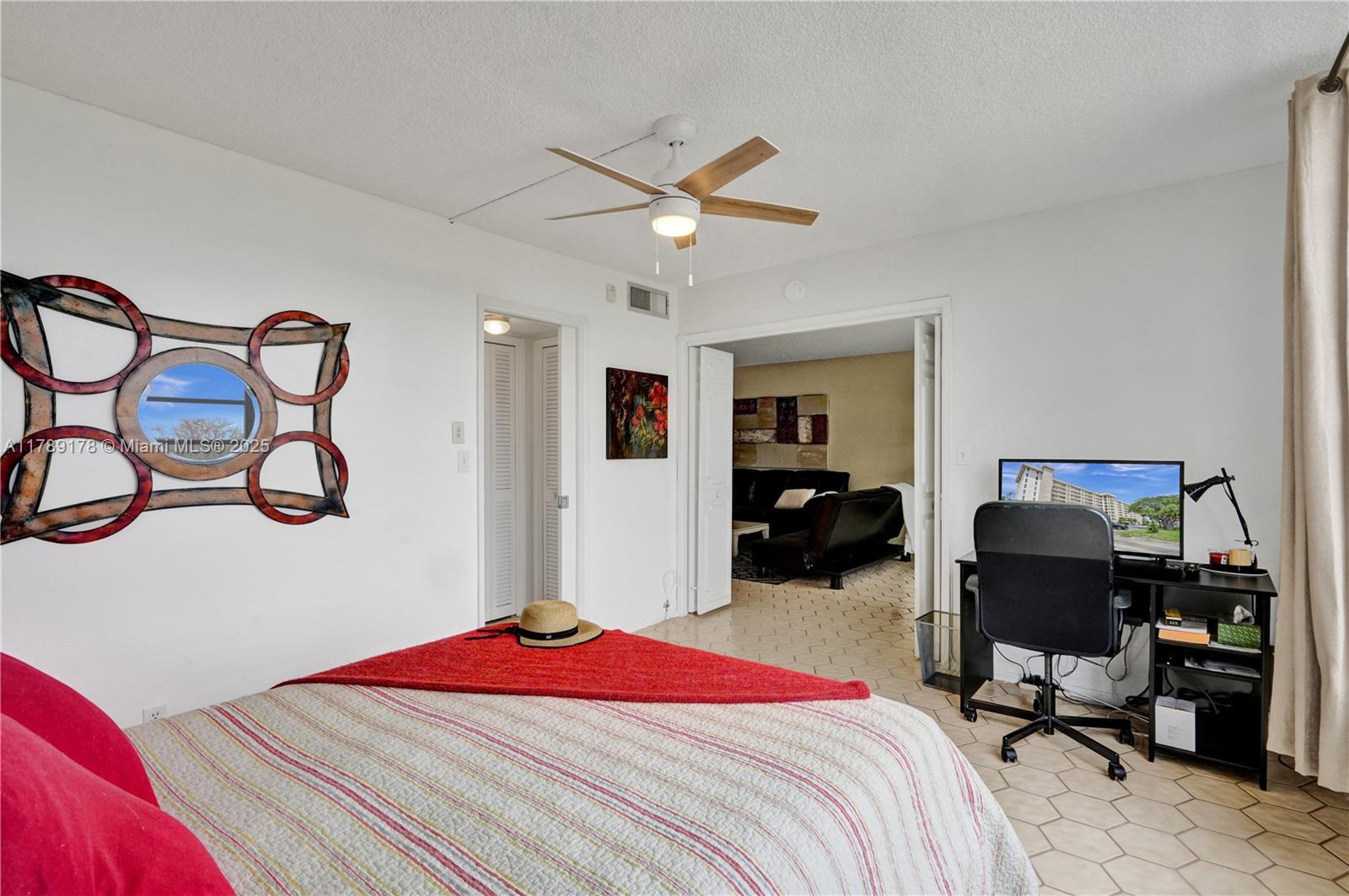 2671 South Course Drive, Unit 409 Pompano Beach, FL 33069 - Photo 28 of 45 a bedroom with a bed and a chair