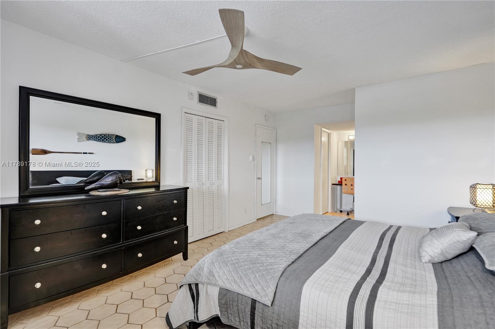 2671 South Course Drive, Unit 409 Pompano Beach, FL 33069 - Photo 32 of 45 a bedroom with a bed and a mirror on dresser