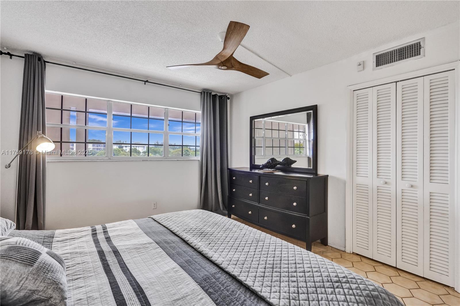 2671 South Course Drive, Unit 409 Pompano Beach, FL 33069 - Photo 34 of 45 a bedroom with a bed and a mirror