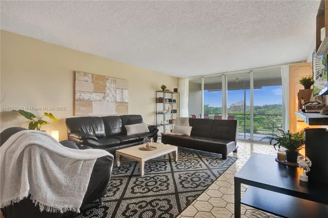 a living room with furniture and a floor to ceiling window