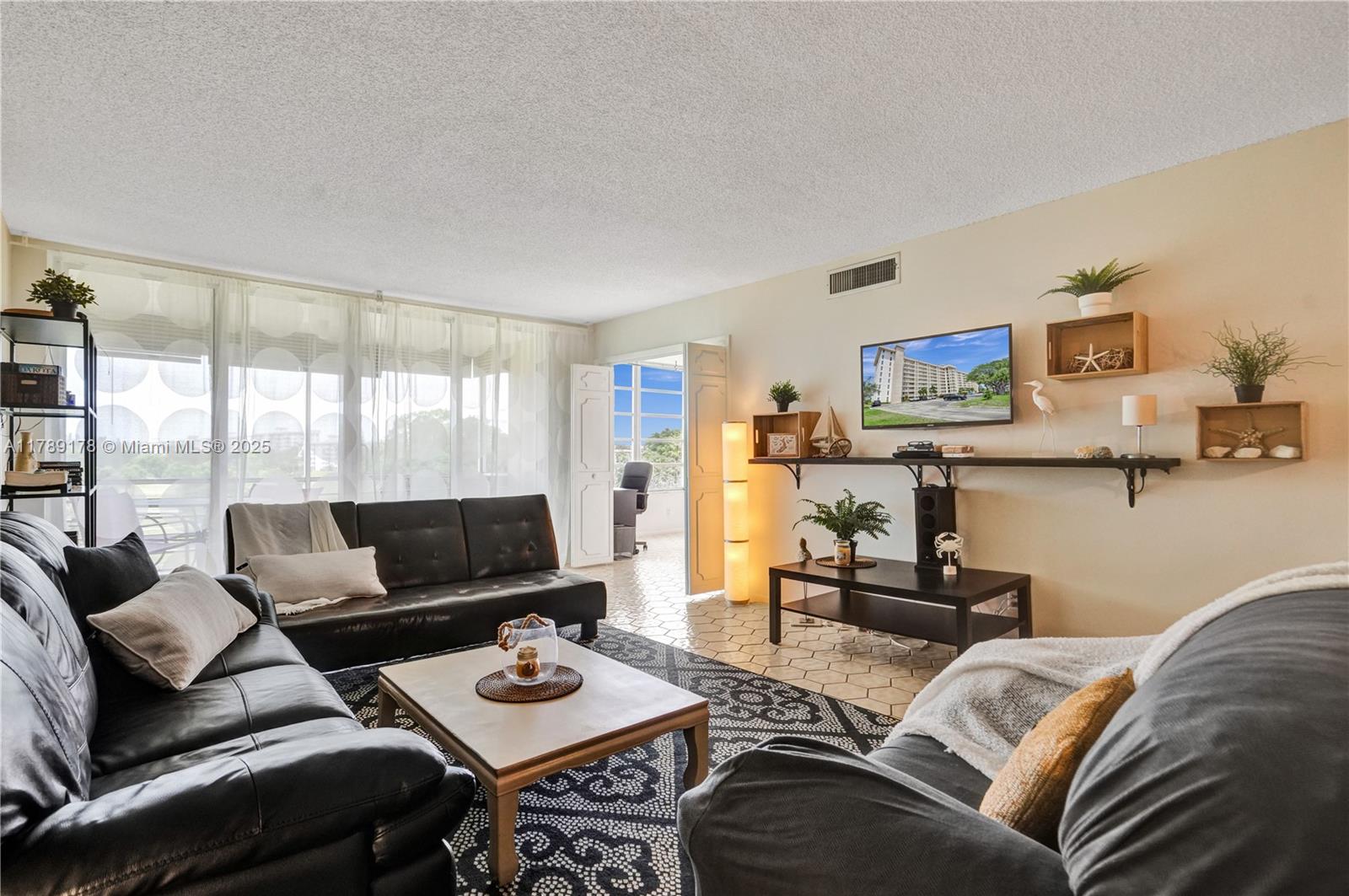2671 South Course Drive, Unit 409 Pompano Beach, FL 33069 - Photo 6 of 45 a living room with furniture and a floor to ceiling window