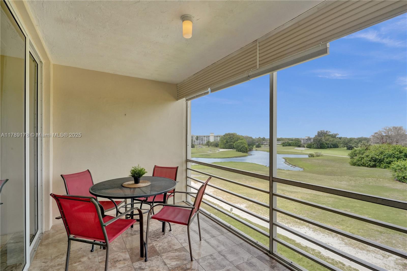 2671 South Course Drive, Unit 409 Pompano Beach, FL 33069 - Photo 9 of 45 a view of a room with a table and chairs and wooden floor