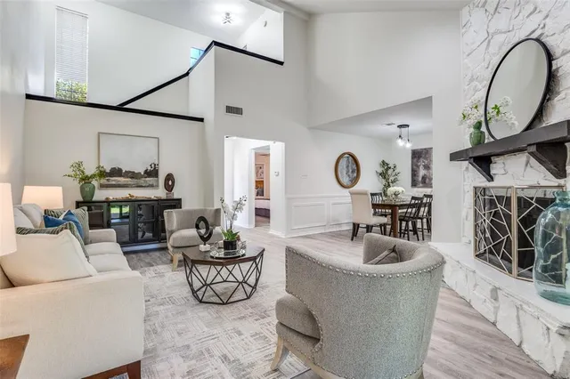a living room with furniture a fireplace and a large window