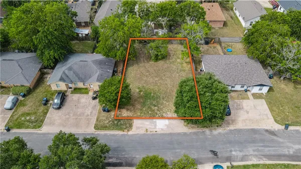 an aerial view of a house with garden space and a street view