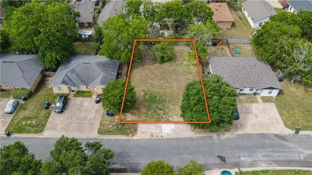 an aerial view of a house with garden space and a street view